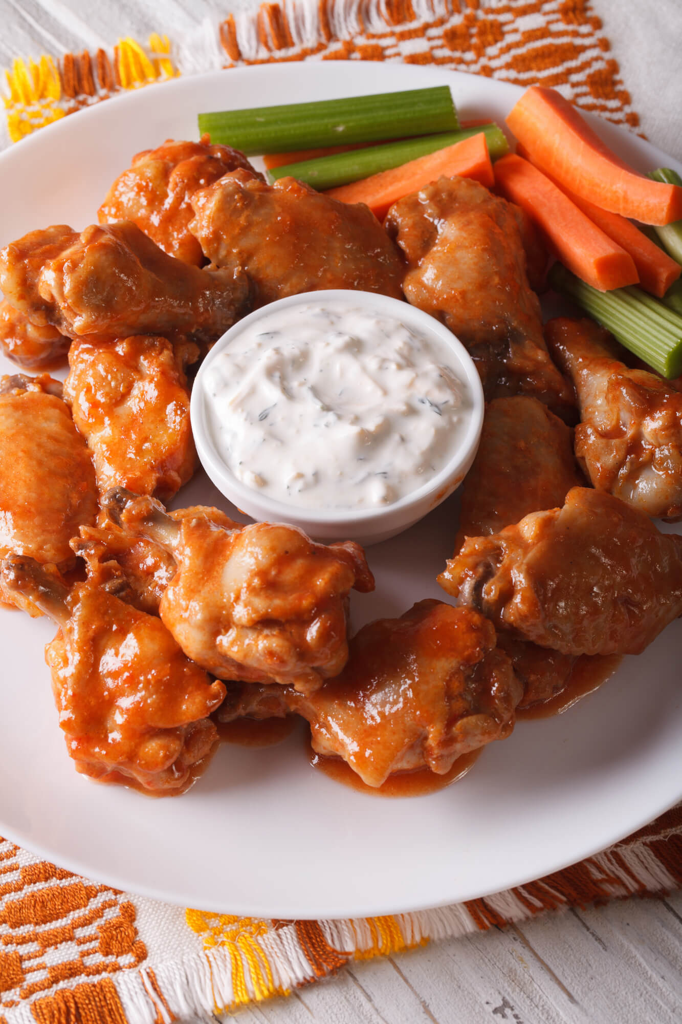 Baked buffalo wings recipe with ranch dressing on a red napkin.