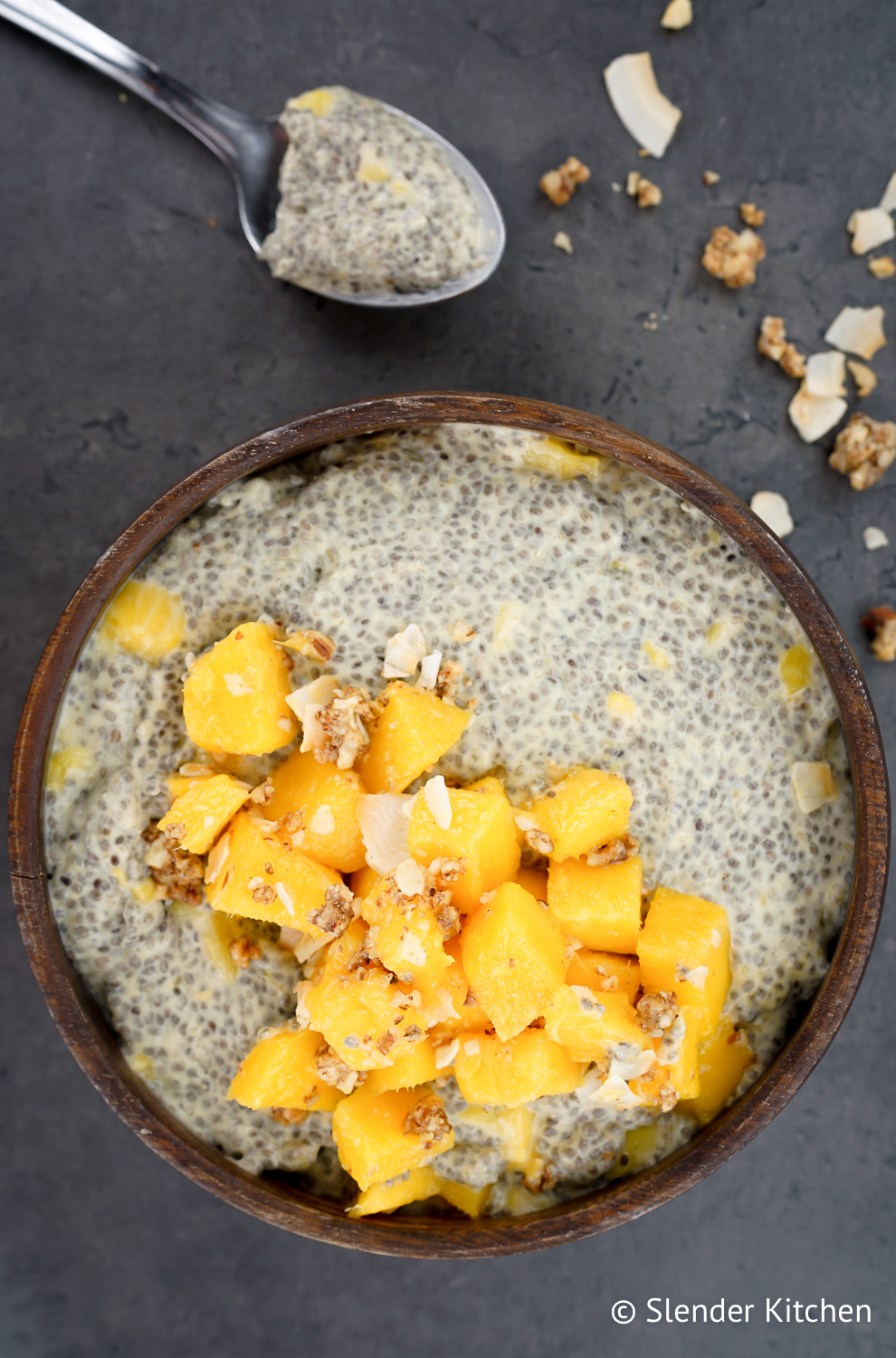 How to make chia pudding with a spoon and granola on a dark slate background.