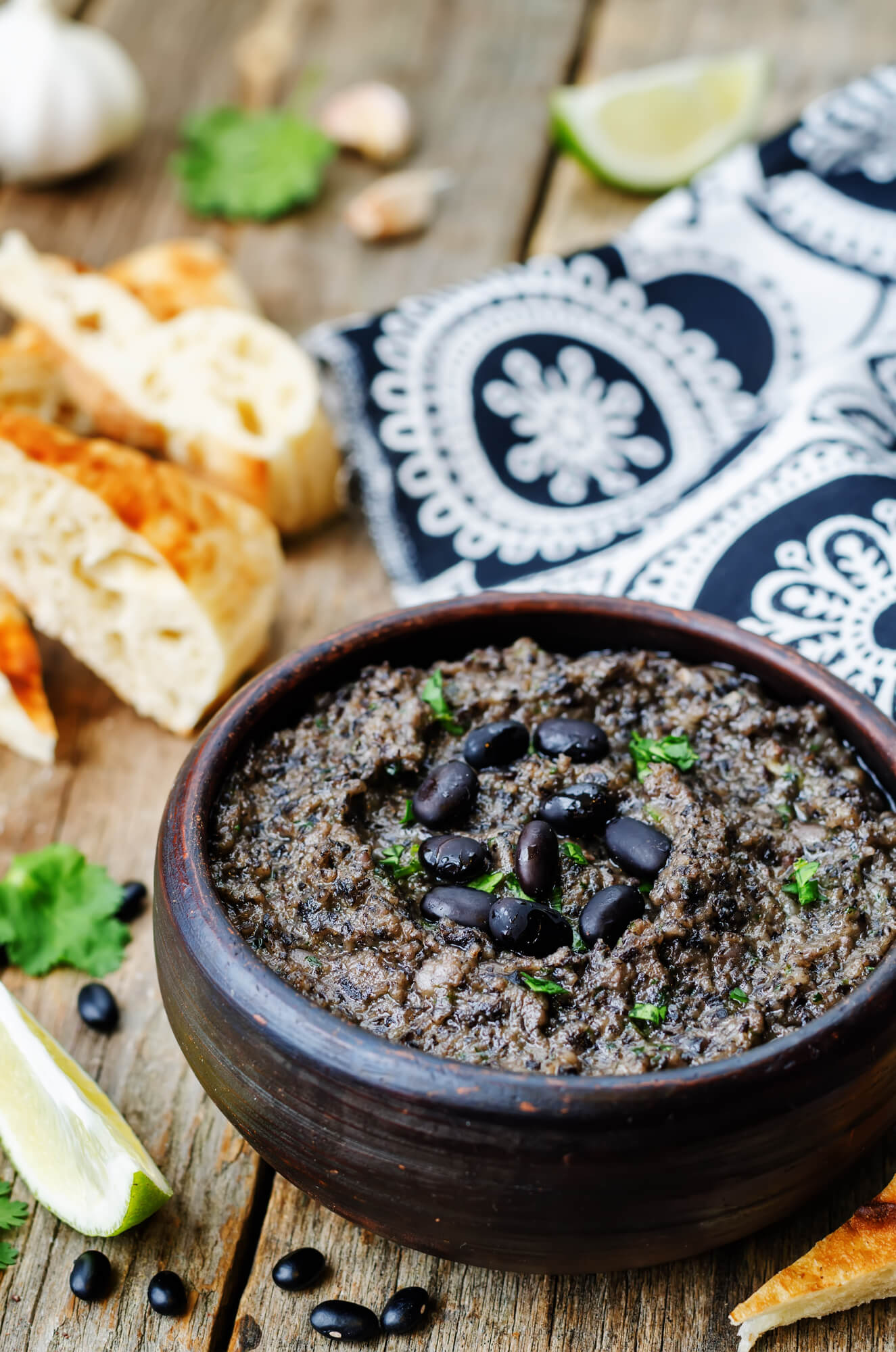 Black Bean Hummus is a wooden bowl with cilantro and garlic.