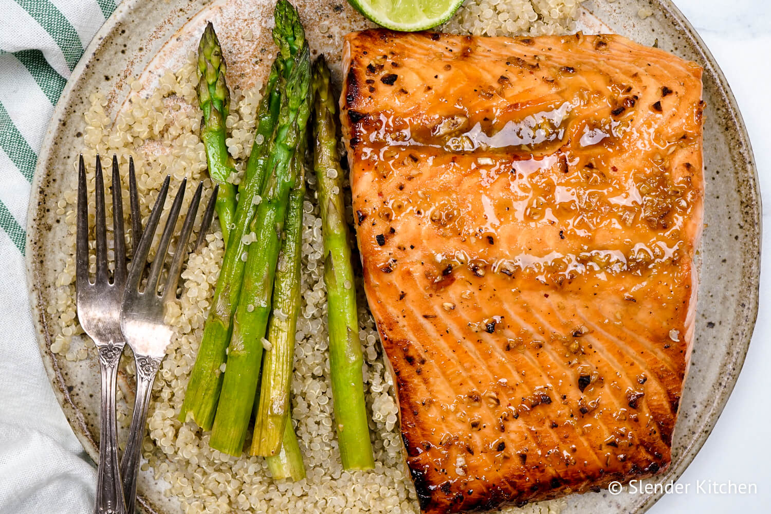 Broiled salmon on a plate with quinoa and asparagus.