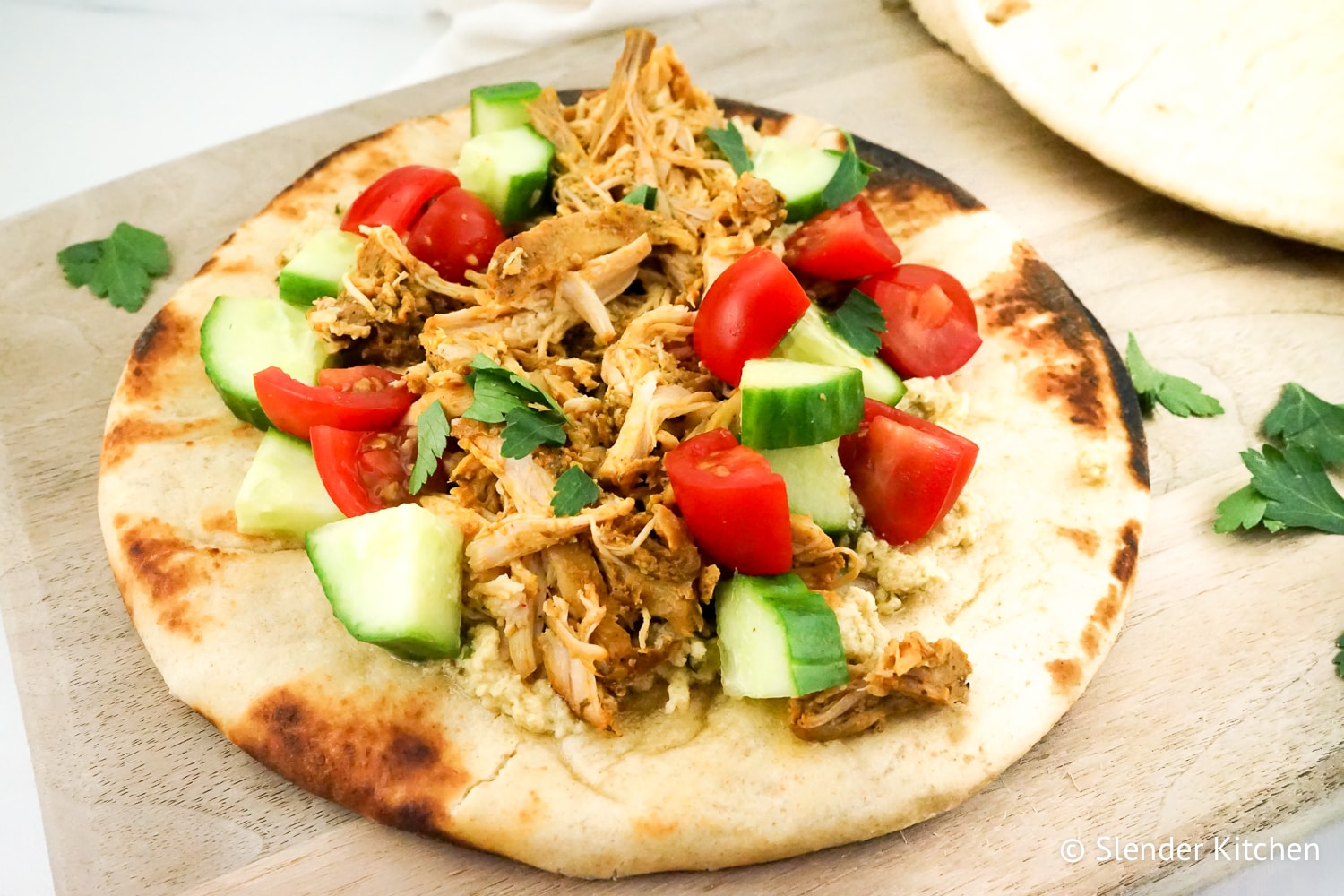 Instant Pot Chicken Shawarma on a pit up with cucumbers and tomatoes