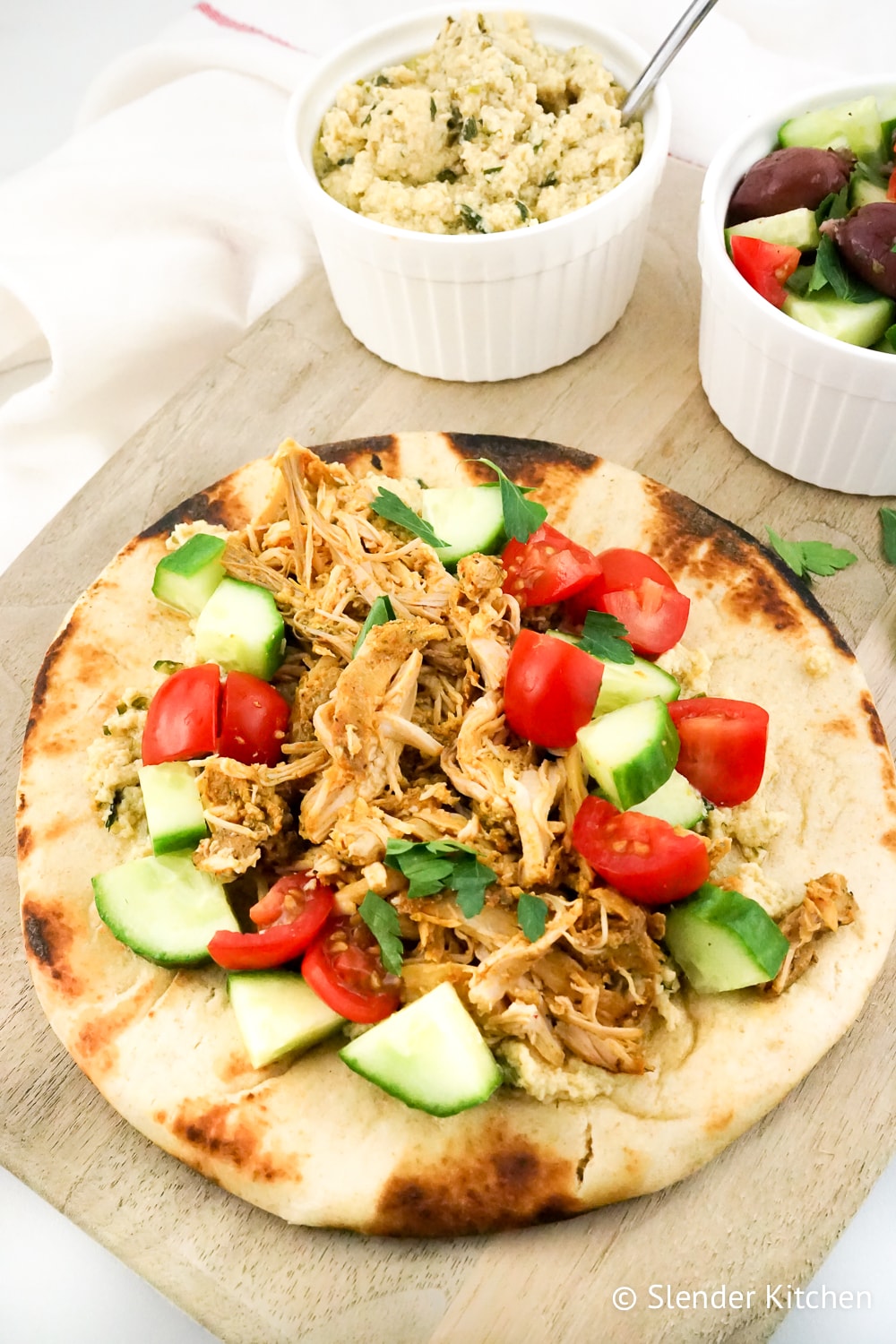 Slow Cooker Chicken Shawarma in a pita with hummus and salad.