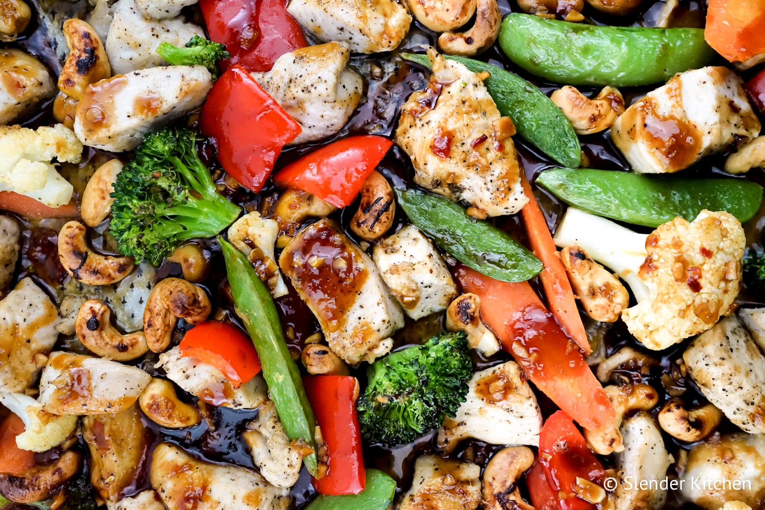 Thai Cashew Chicken and Vegetables on a sheet pan with a sticky sweet and spicy sauce.