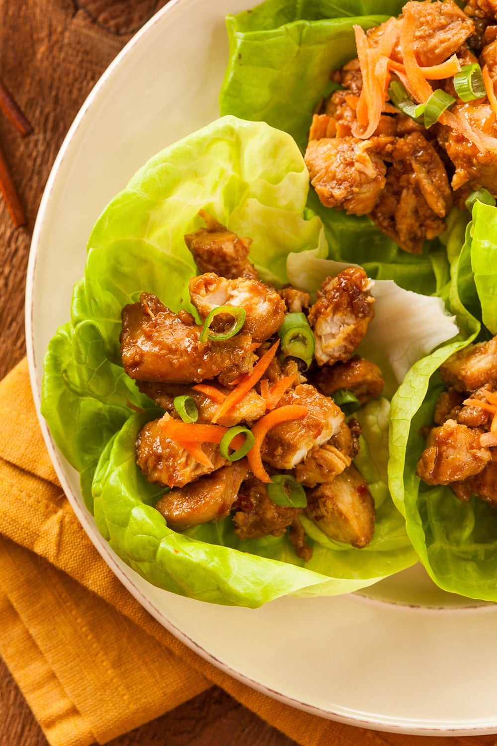Crockpot Korean Chicken on a plate with lettuce and carrots.