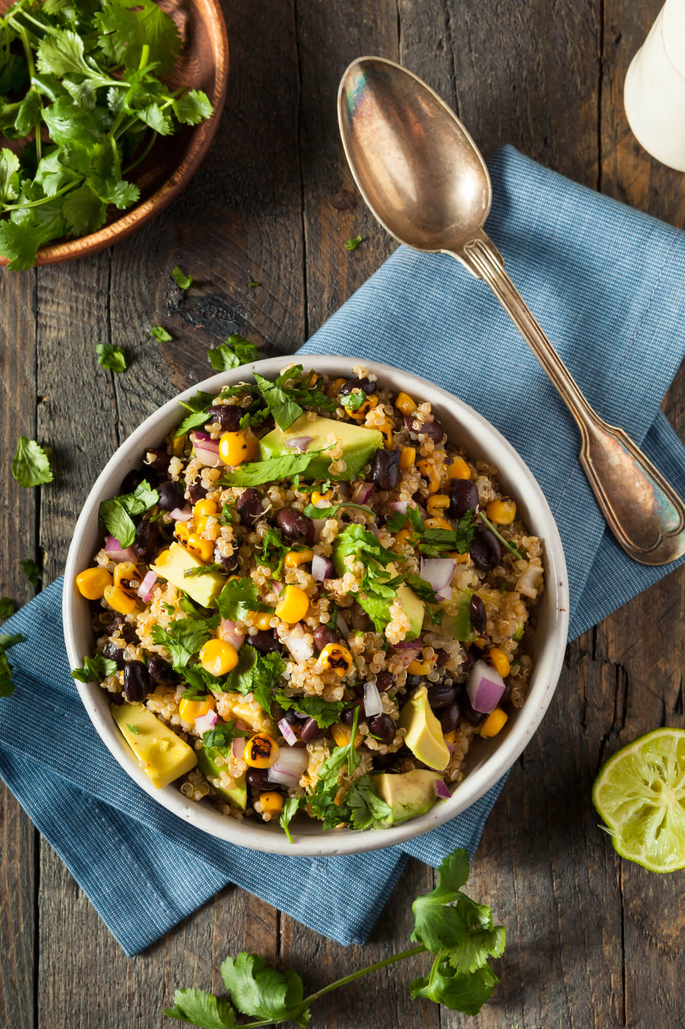Southwestern Quinoa salad with black beans, corn, and avocado in a bowl with a spoon.