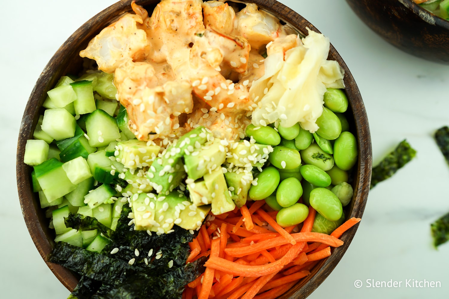 Spicy Shrimp Sushi Bowls in a wooden dish with sesame seeds and seaweed.
