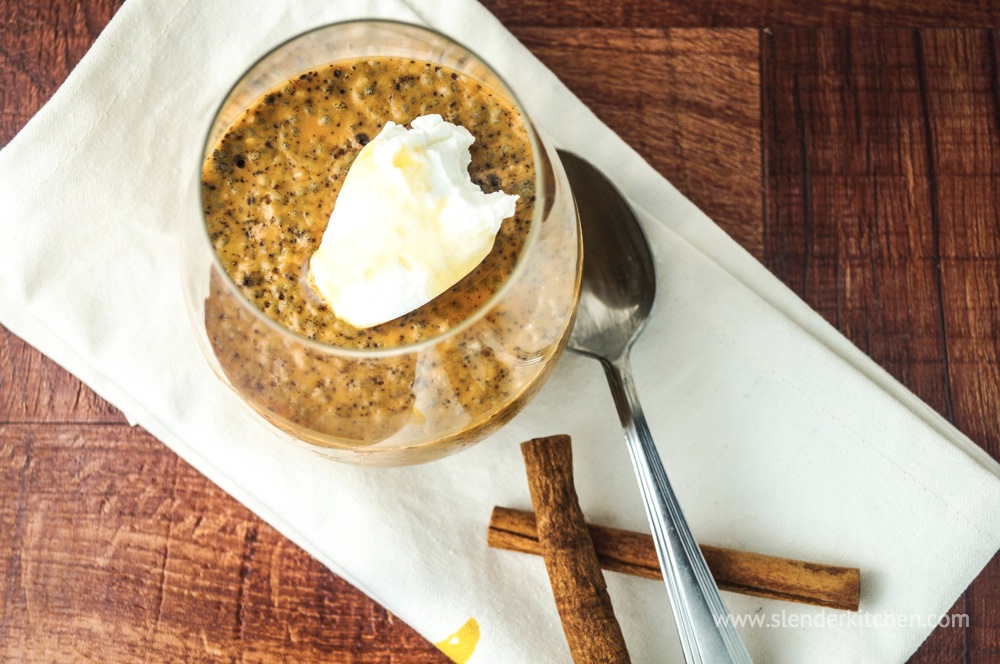 Pumpkin chia seed pudding with a cinnamon stick and white napkin.