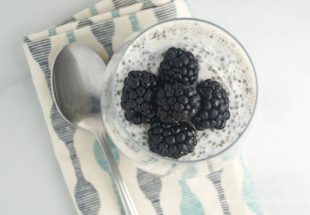 Chia pudding with yogurt on a blue and white napkin with a spoon.