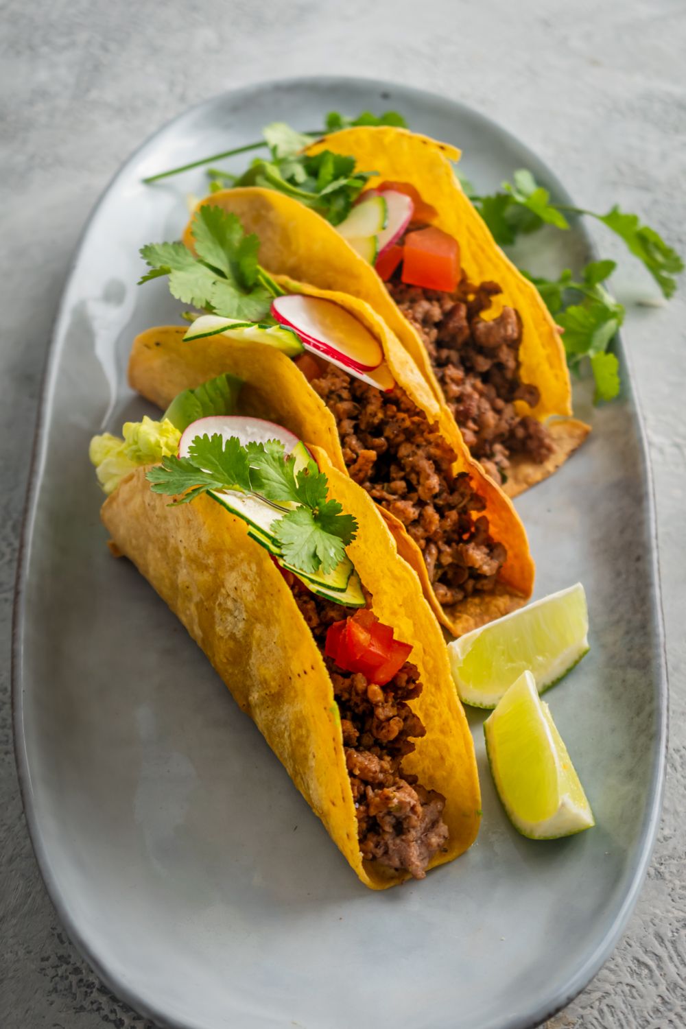 Baked corn taco shells filled with ground turkey, tomatoes, avocado, cilantro, and radish.