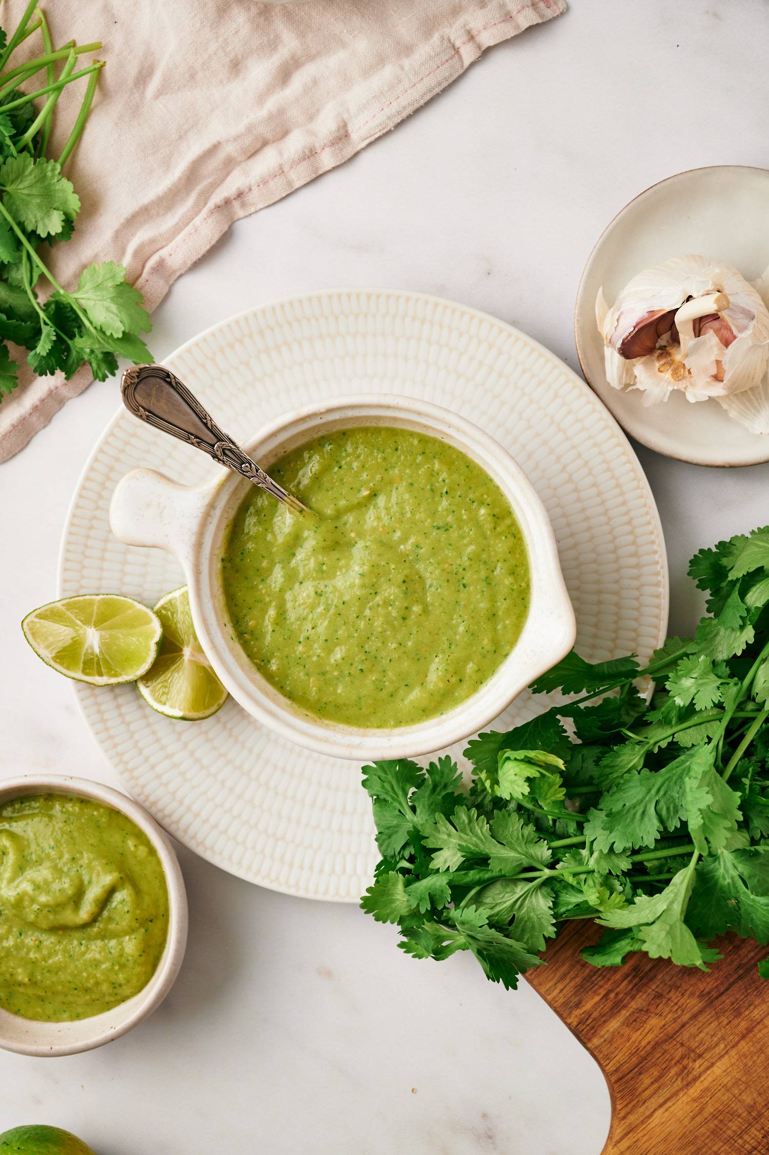 Avocado salsa verde served with extra cilantro and limes on the side.