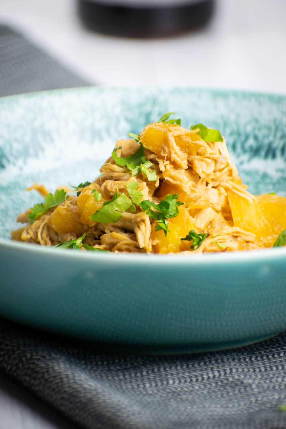 Hawaiian chicken that is shredded with pineapple and cilantro in a bowl.