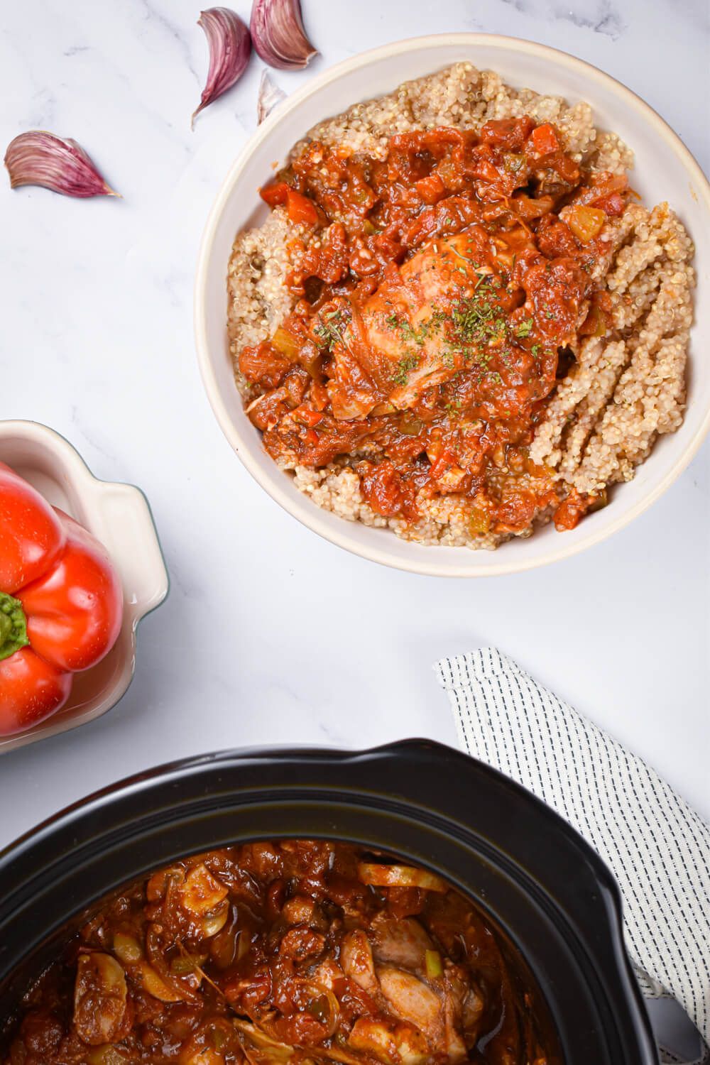 Crockpot chicken cacciatore in a bowl with quinoa and a crockpot with chicken in tomato sauce.