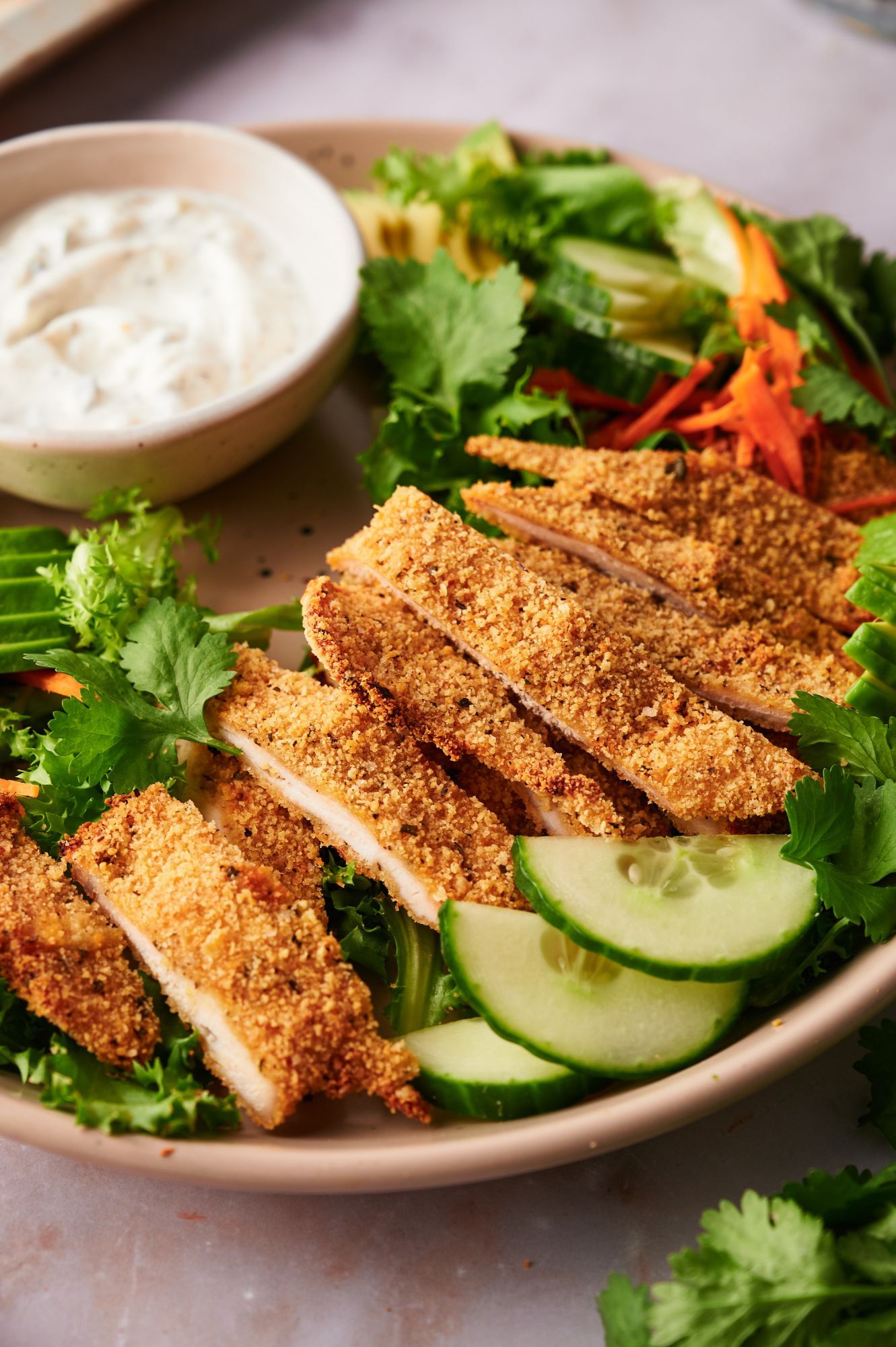 Crispy chicken cutlets sliced and served with salad. 