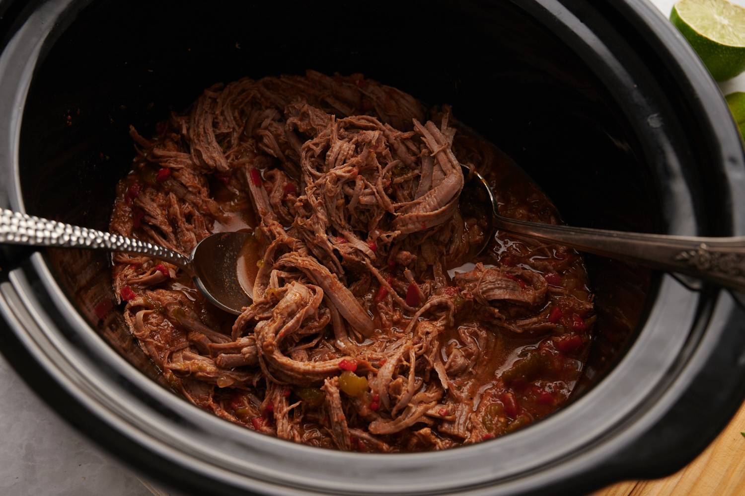 Slow cooker beef machaca with peppers, onions, and tomatoes.