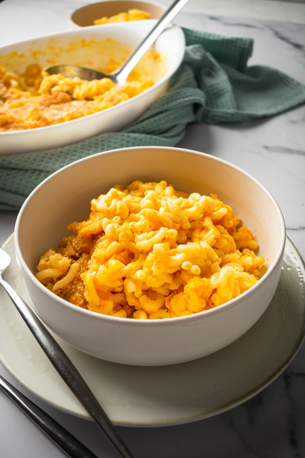 Carrot macaroni and cheese on a bowl with a cheddar cheese sauce and elbow macaroni.