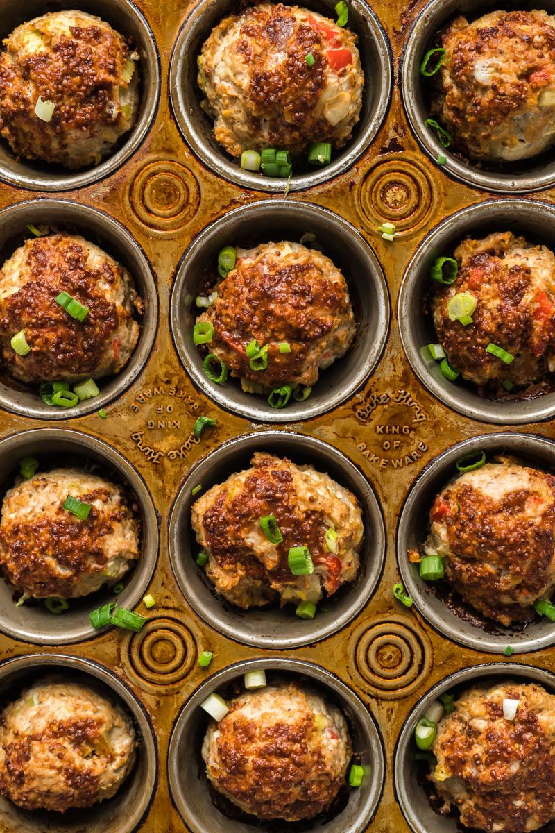 Single serving meatloaf muffins with ground turkey topped with barbecue sauce and mustard in a muffin tin.