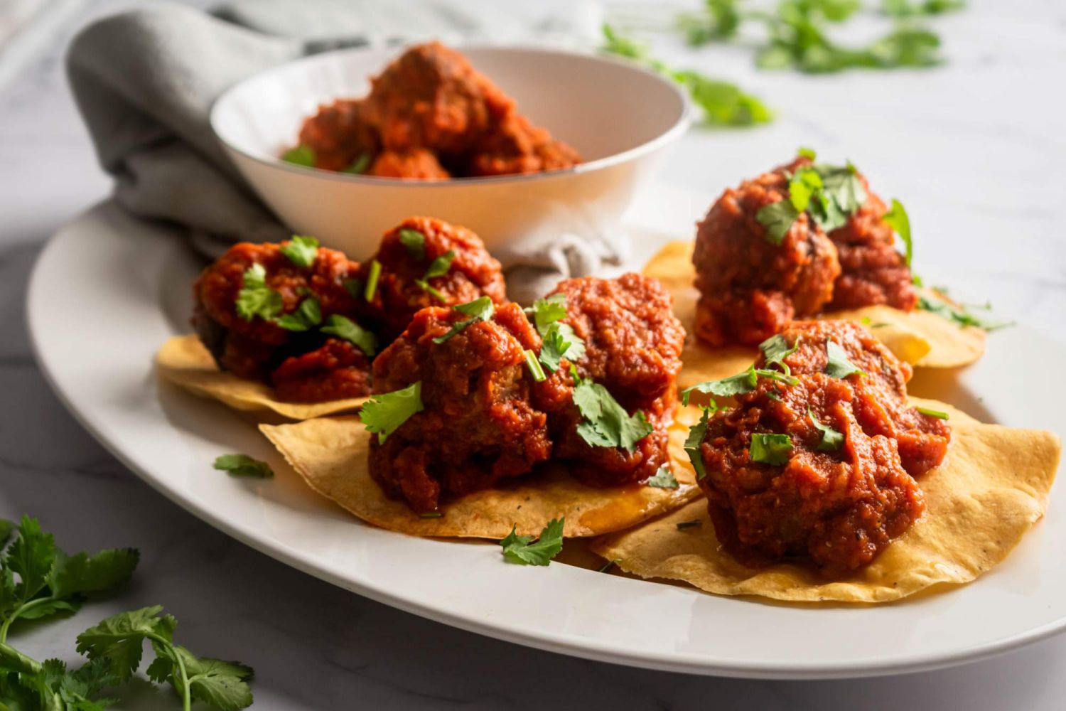 Meatballs simmered in a Mexican chipotle sauce and served on corn tortillas with chopped cilantro.