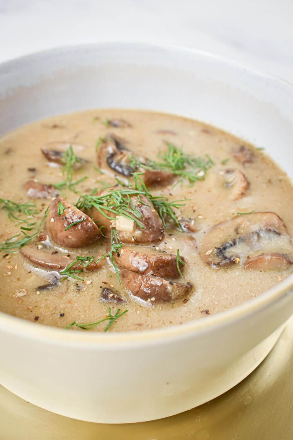 Creamy mushroom soup in a bowl with cooked mushrooms in a creamy broth.