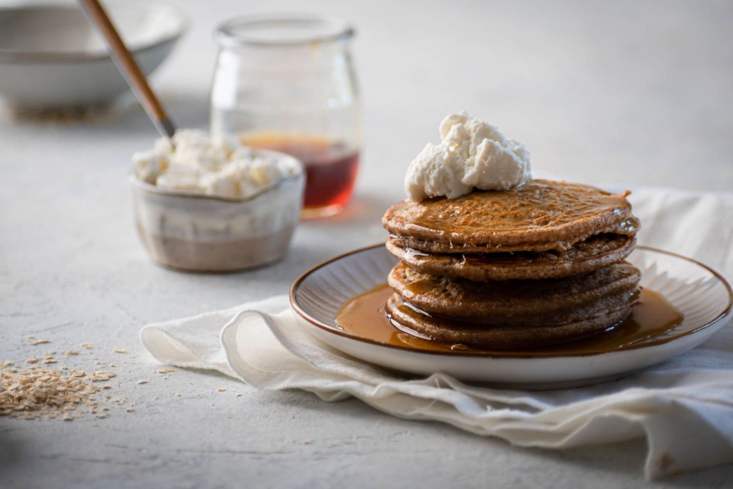Oatmeal pancakes with extra protein from cottage cheese and egg whites served with whipped cream and syrup.