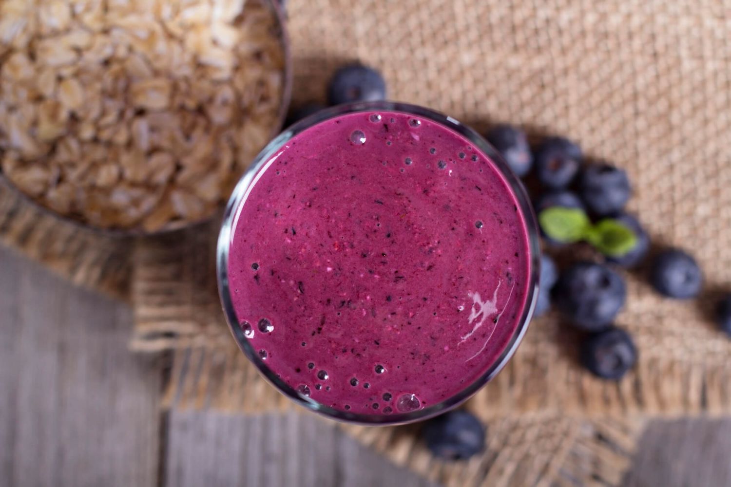 Overhead photo of an oatmeal protein smoothie with blurred background and berries.