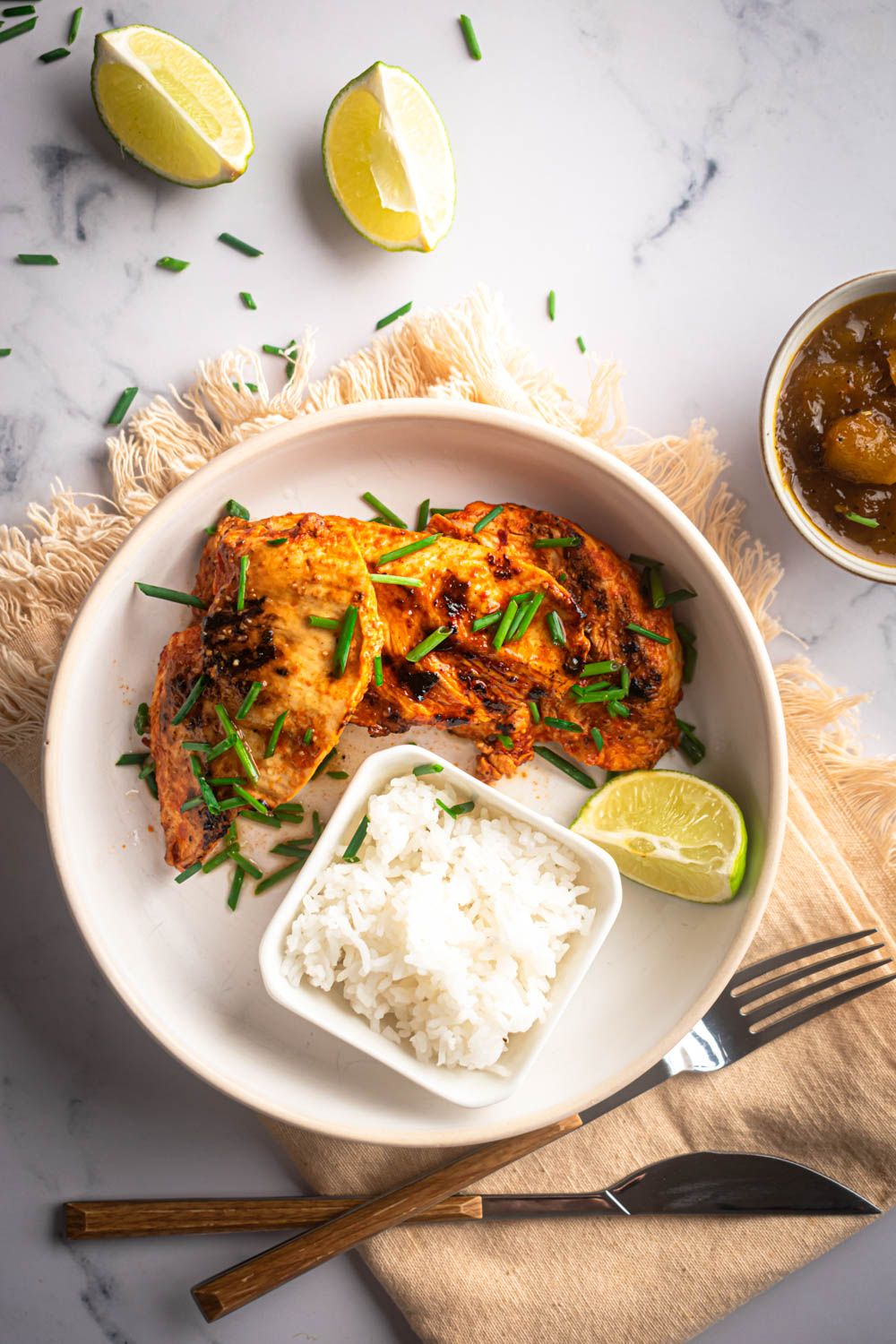 Paprika chicken breast with garlic and lime juice served with white rice, green onions, and mango chutney. 