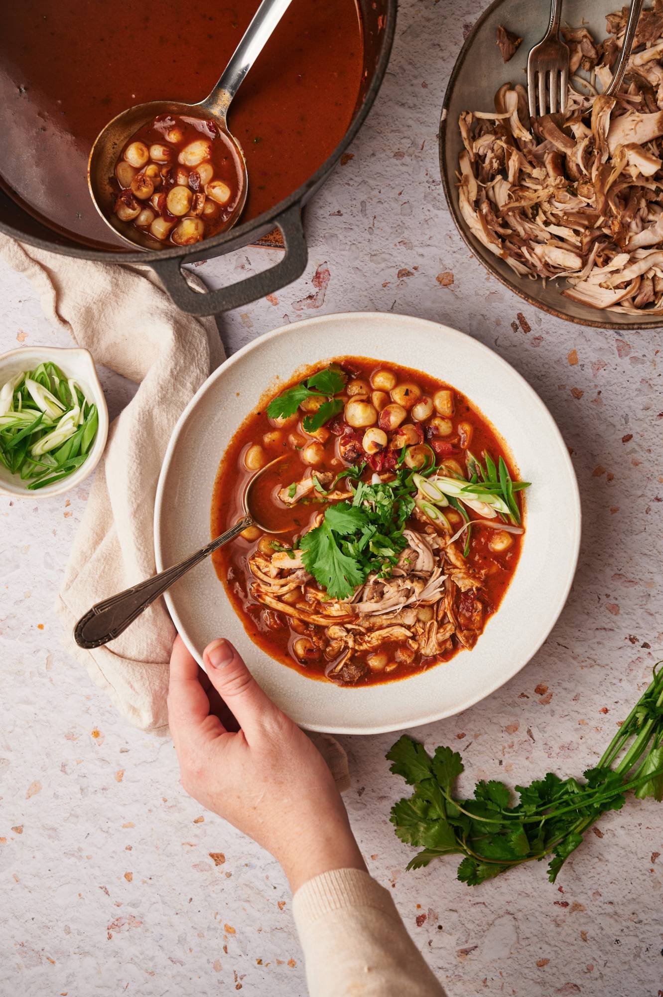 Red chicken pozole with shredded chicken and hominy in a rich dried chile broth with cilantro.