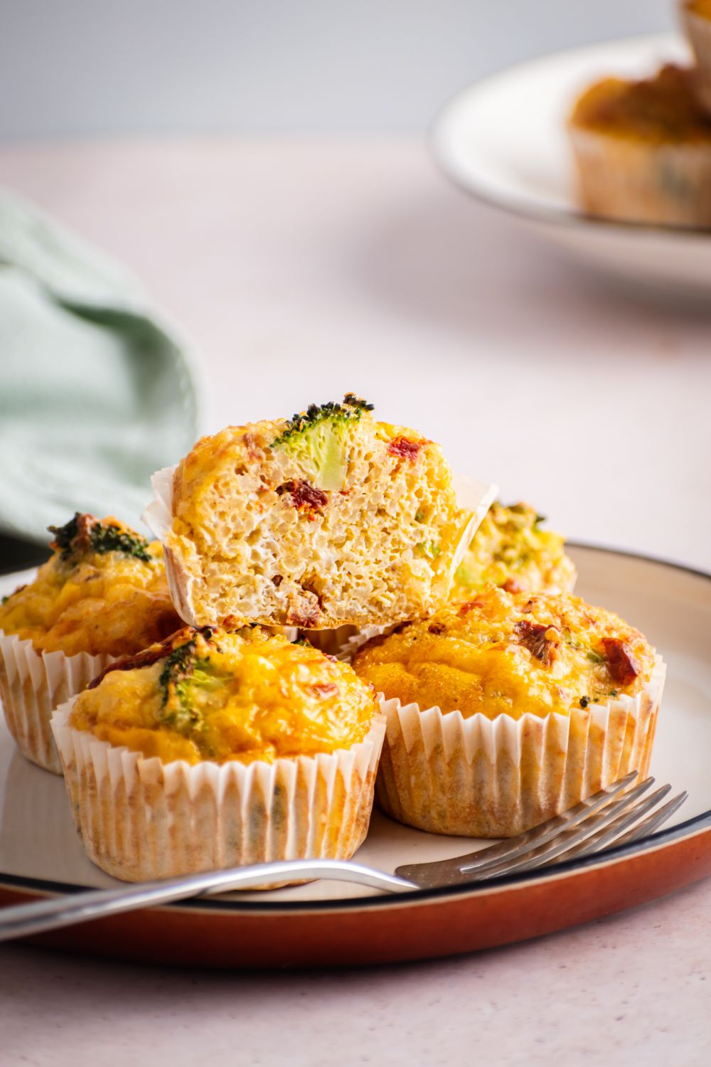 Egg muffins with quinoa, broccoli, and sundried tomatoes on a plate.