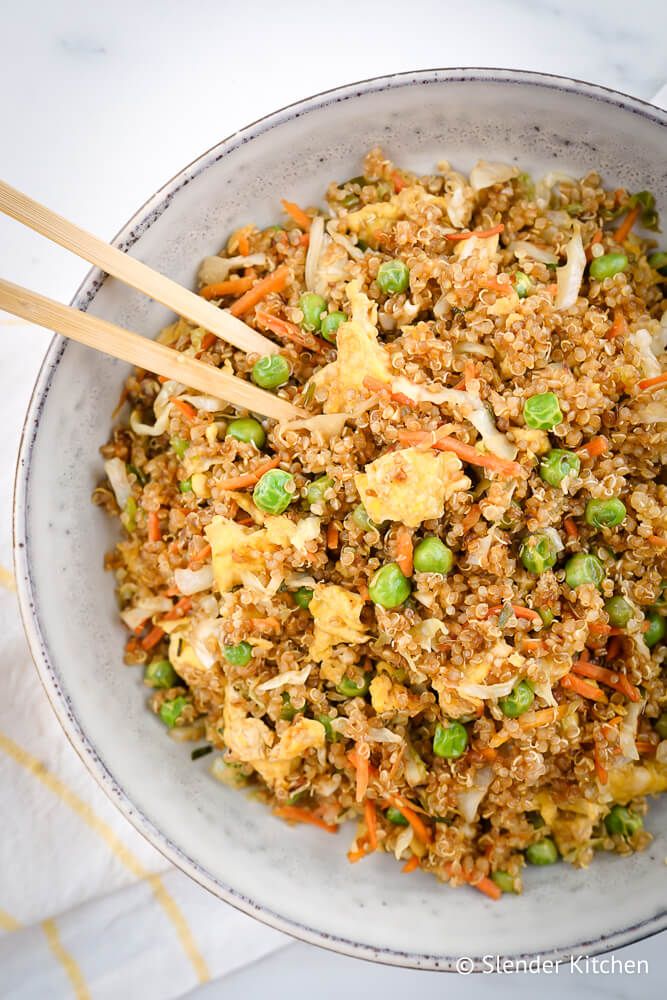 Quinoa fried rice in a bowl with quinoa, vegetables, eggs, and soy sauce. 