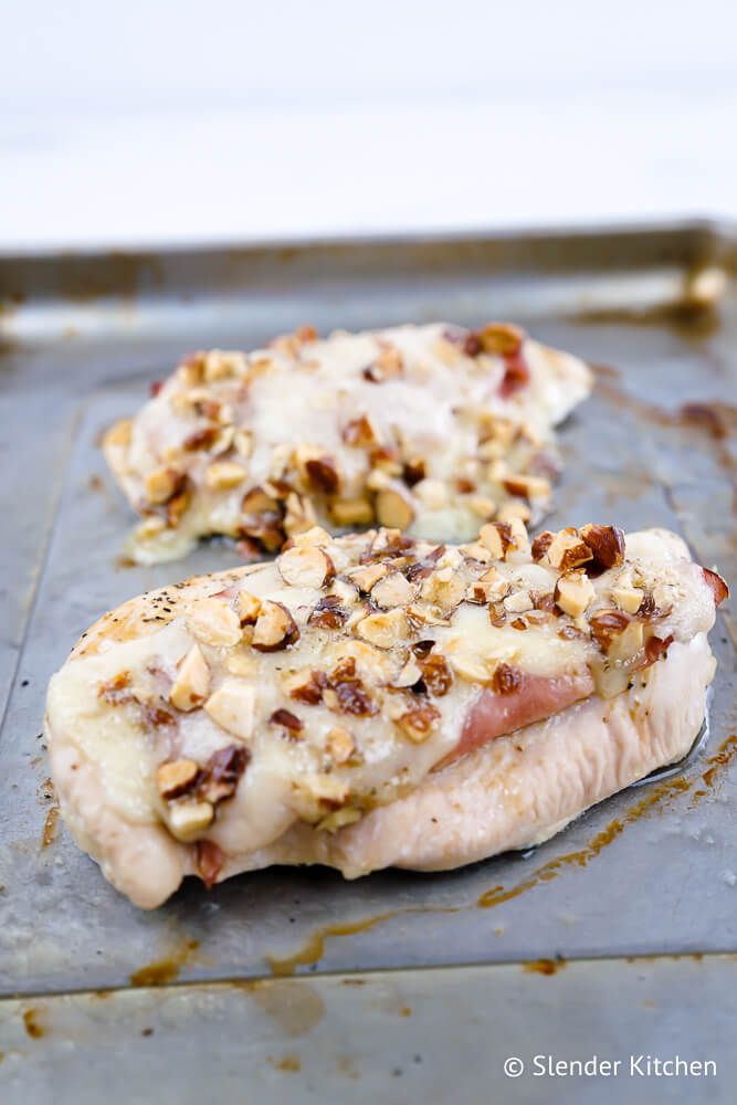Shortcut Chicken Cordon Bleu with melted cheese, ham, and almonds on a sheet pan.