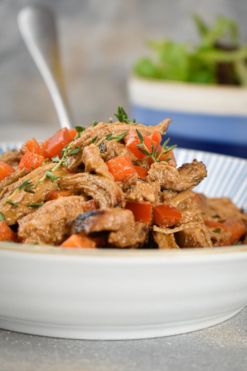 Slow cooker paprikash with pork, tomatoes, peppers, and sour cream in a bowl.