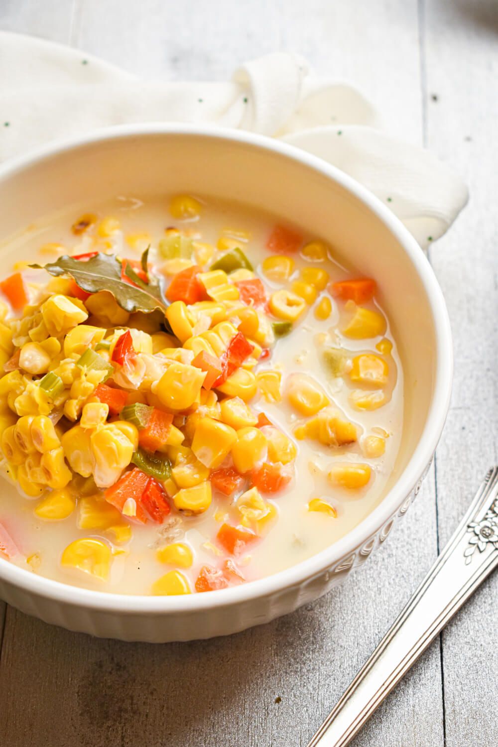 Crockpot roasted corn chowder with vegetables in a bowl with a napkin.