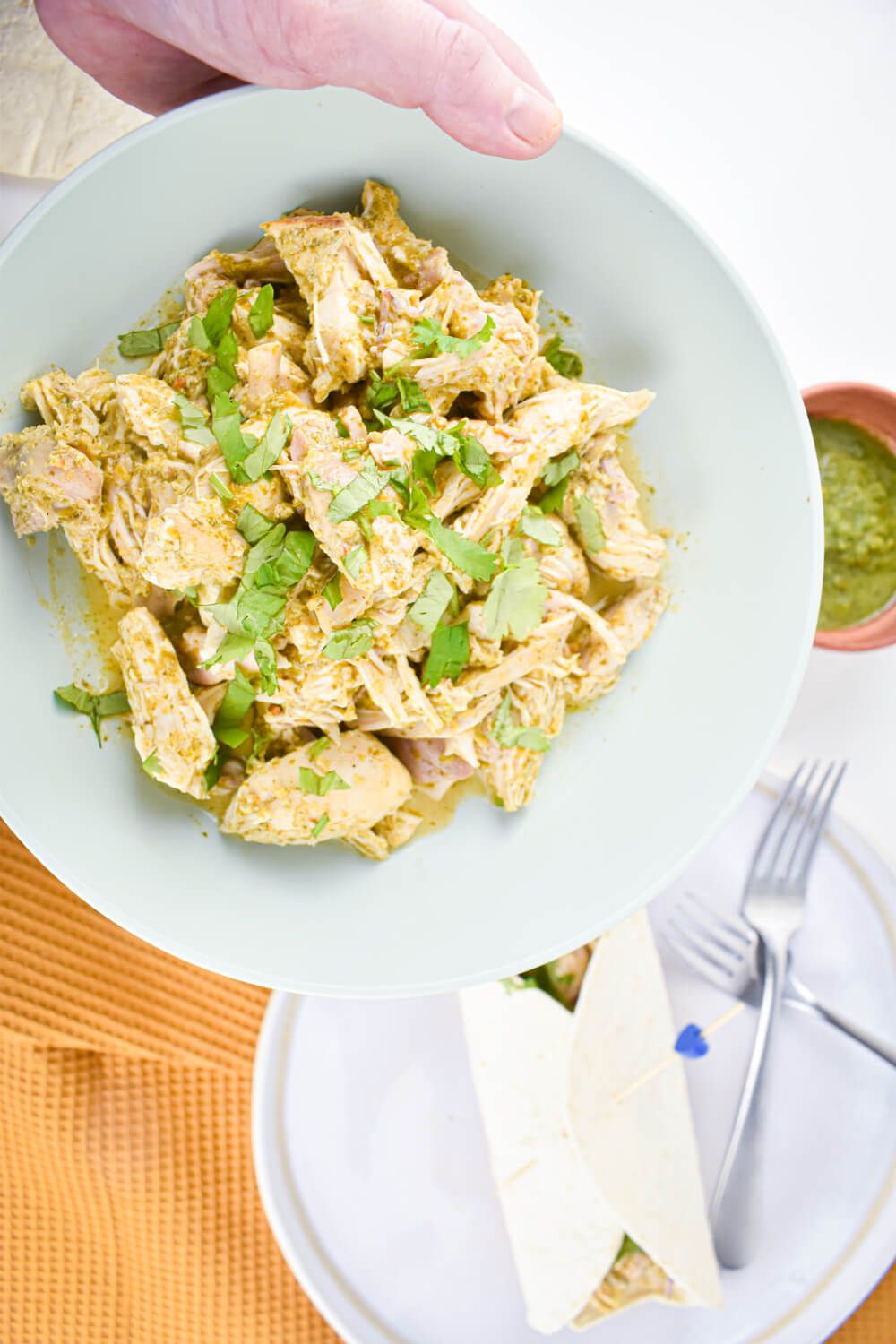 Salsa verde chicken shredded and served in a flour tortilla with cilantro and onions.