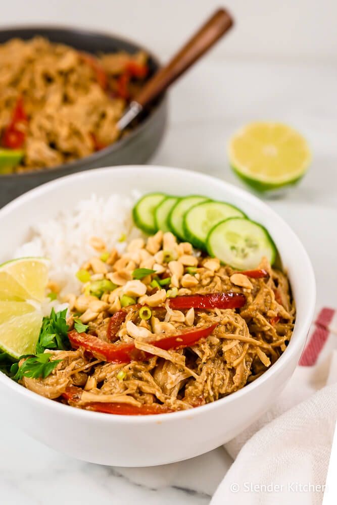 Crockpot peanut chicken with red peppers in a creamy peanut sauce with cilantro and cucumbers.