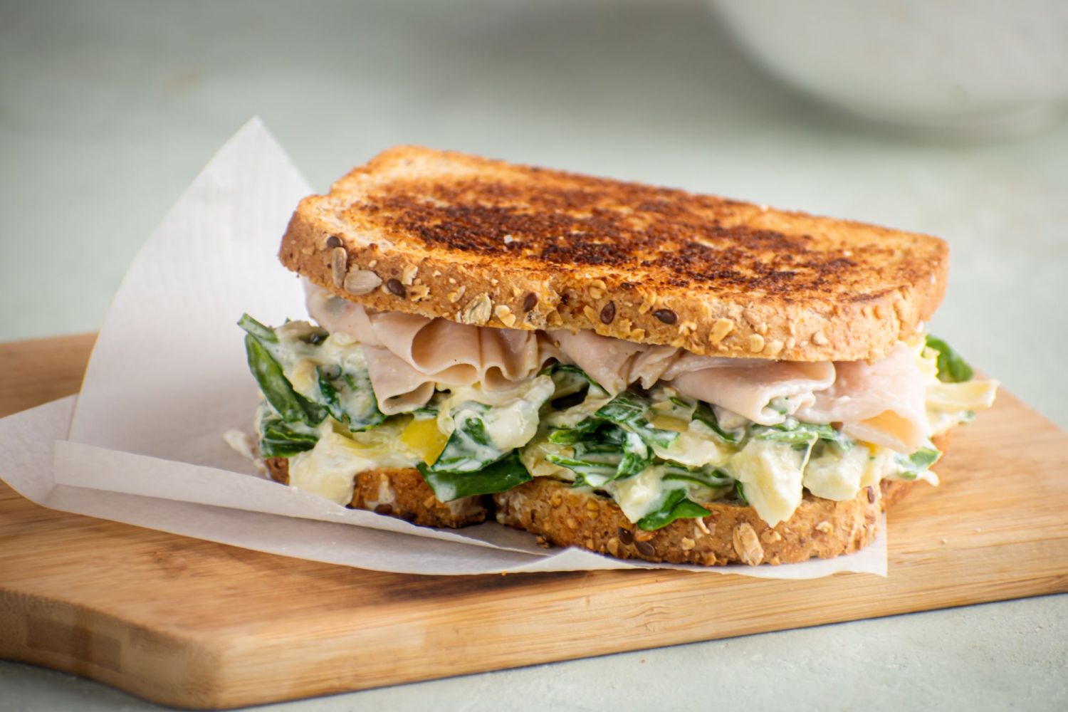 Grilled cheese with spinach, artichoke, cream cheese, and mozzarella cheese served on toasted wheat bread.