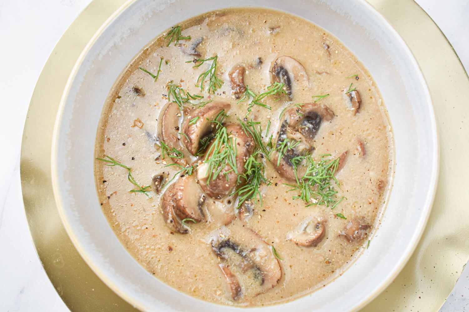 Mushroom soup with fresh cooked mushrooms, garlic, onion, and thyme in a healthy creamy broth.