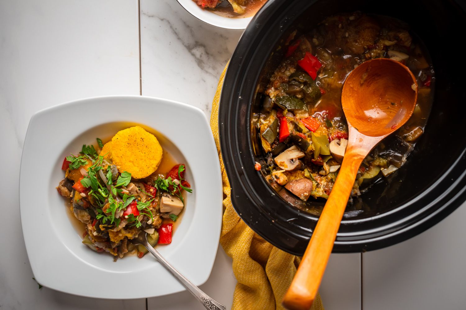 Slow cooker ratatouille with eggplant, zucchini, tomatoes, and mushrooms served with polenta on the side.