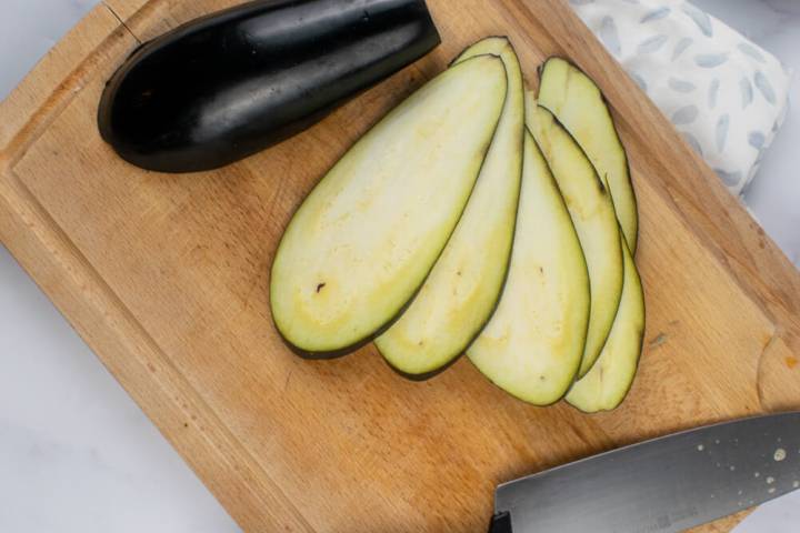Sliced eggplant on a cutting board.