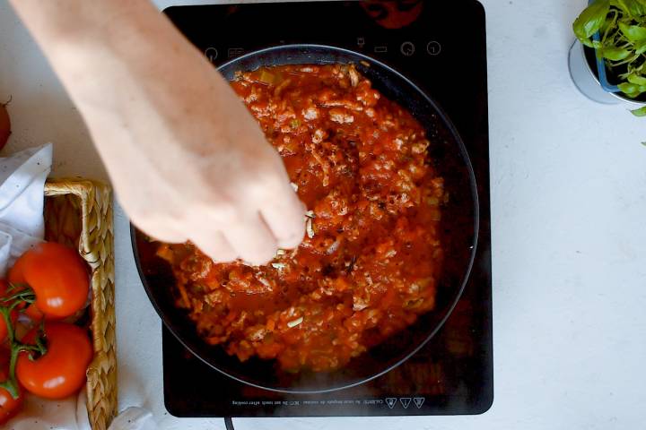 Ground turkey bolognese simmering in a skillet.
