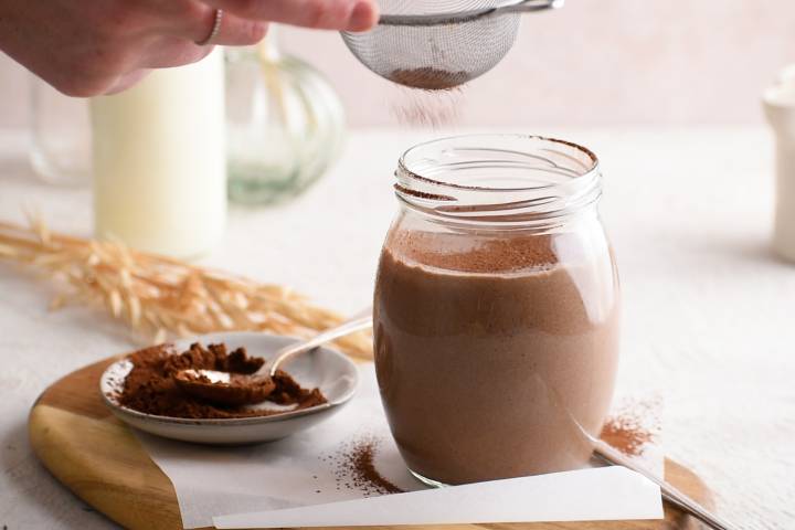 Chocolate breakfast shake being dusted with unsweetened coca powder.