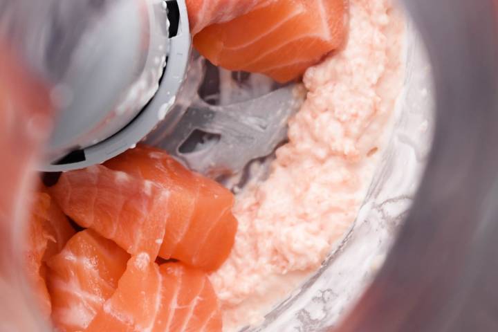 Easy Salmon Burgers Fresh salmon chunks being added to a food processor.
