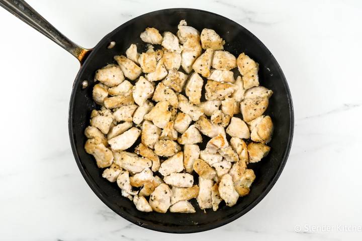 Seared chicken breast pieces in a skillet.