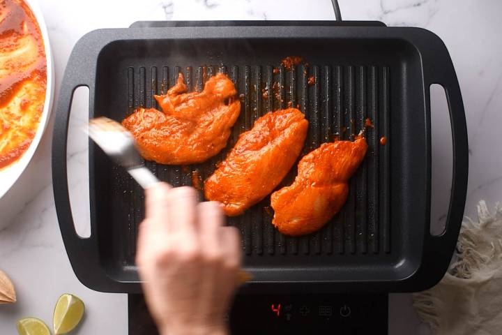 Paprika lime chicken cooking on a grill pan.