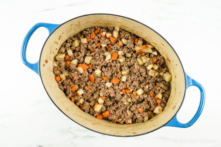 Ground beef with potatoes, carrots, onions, and garlic for picadillo.