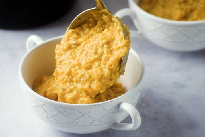 Pumpkin steel cut oatmeal being poured into a cup.