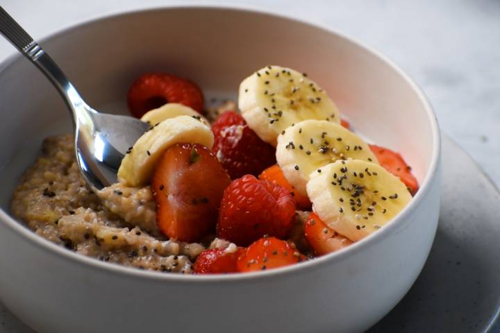 Steel cut oats with fruit in a bowl with a spoon.