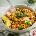 Healthy Mexican corn salad in a bowl with cilantro, corn, cheese, and jalapenos.