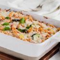 Roasted Vegetable Baked Ziti with melted cheese in a white casserole dish.