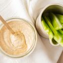 Blackened ranch dressing with yogurt and buttermilk in a glass jar with celery sticks.
