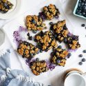 Blueberry oat bars with roasted blueberries and a oatmeal crumb topping cut into squares.