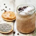 Chocolate peanut butter chia seed pudding served in a glass jar with peanut butter and chia seeds on the side.